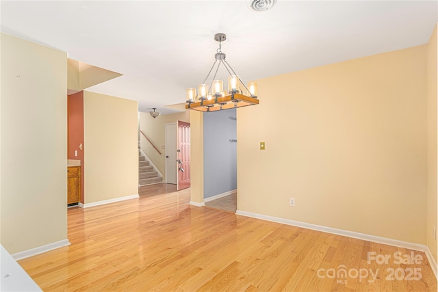 111 Clubwood Ct, Asheville, NC 28803 - unfurnished room featuring a chandelier, stairs, light wood-style flooring, and baseboards
