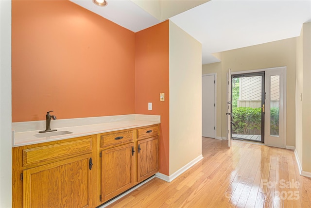 111 Clubwood Ct, Asheville, NC 28803 - bar area featuring a sink, light wood-style floors, and baseboards