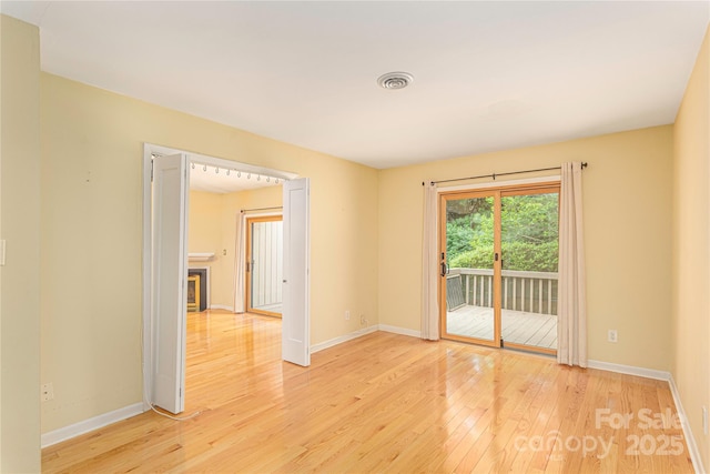 111 Clubwood Ct, Asheville, NC 28803 - unfurnished room with light wood-style floors, baseboards, and a glass covered fireplace