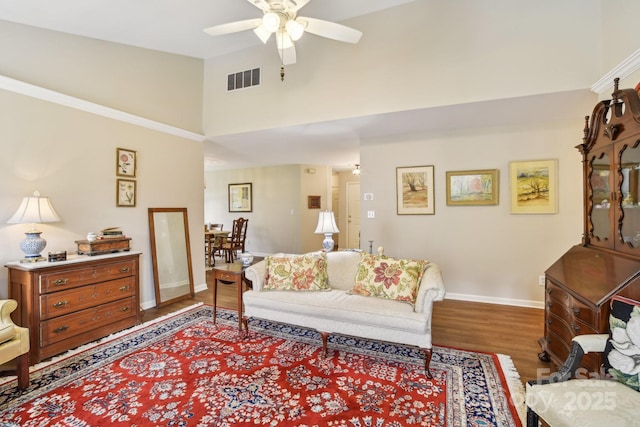living room with high vaulted ceiling, ceiling fan, wood finished floors, and baseboards