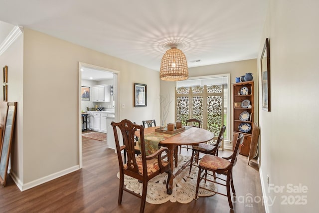 dining space with dark wood-style flooring and baseboards