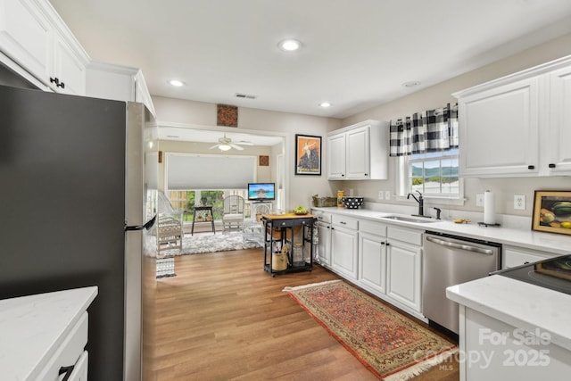kitchen featuring a sink, stainless steel appliances, white cabinets, and recessed lighting