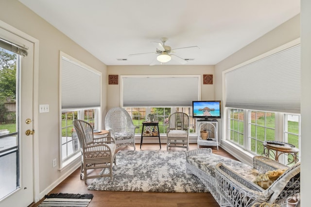 sunroom / solarium featuring plenty of natural light, wood finished floors, and baseboards