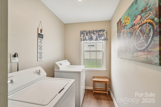 laundry room with washing machine and clothes dryer, wood finished floors, and baseboards