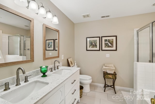 bathroom with a stall shower, tile patterned floors, toilet, double vanity, and baseboards