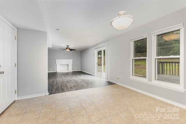 2112 Flint Glenn Ln, Charlotte, NC 28262 - unfurnished living room with ceiling fan, a fireplace with raised hearth, baseboards, and tile patterned floors