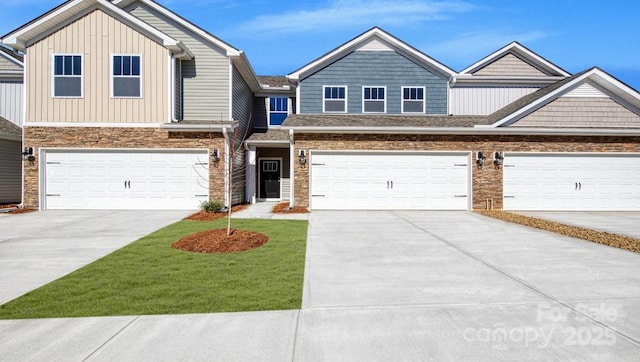 townhome / multi-family property with driveway, board and batten siding, an attached garage, and stone siding