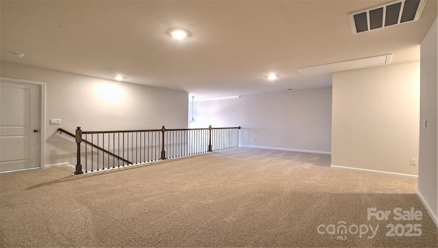 spare room featuring carpet, attic access, baseboards, and recessed lighting