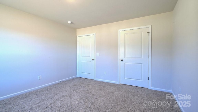 unfurnished bedroom featuring carpet flooring and baseboards