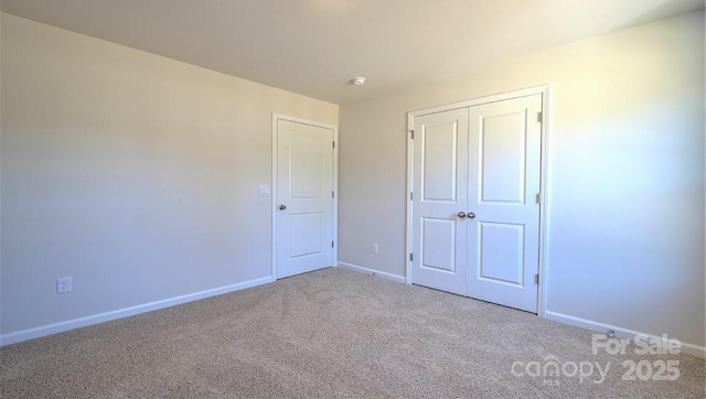 unfurnished bedroom with carpet, baseboards, and a closet