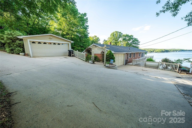 24264 Strand Dr, Albemarle, NC 28001 - single story home featuring a garage, an outbuilding, a water view, and fence