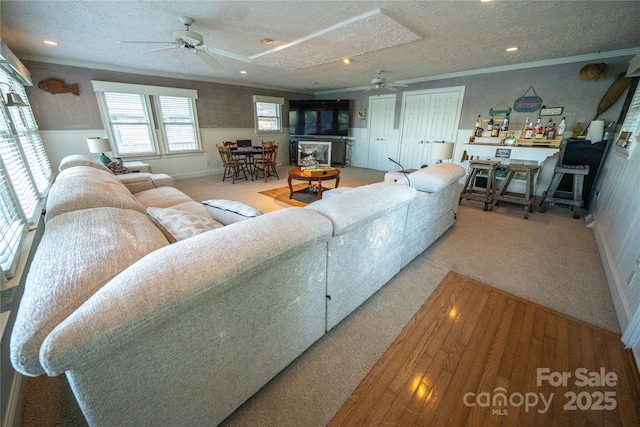 24264 Strand Dr, Albemarle, NC 28001 - carpeted living area with a ceiling fan, a textured ceiling, a wainscoted wall, ornamental molding, and recessed lighting