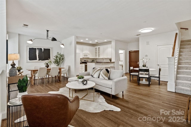 400 N Church St Unit 226, Charlotte, NC 28202 - living area with stairs, wood finished floors, and baseboards