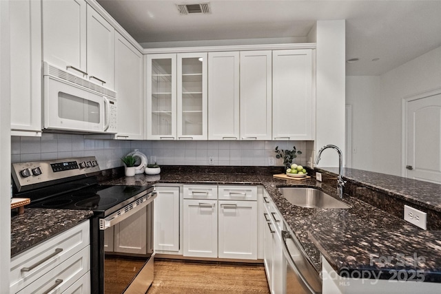 400 N Church St Unit 226, Charlotte, NC 28202 - kitchen featuring electric range, white microwave, a sink, light wood finished floors, and white cabinetry