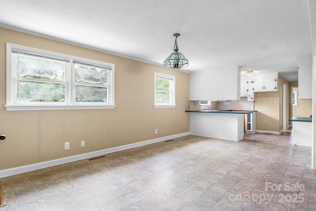 1753 28th St NE, Hickory, NC 28601 - kitchen with a peninsula, dark countertops, white cabinetry, backsplash, and baseboards