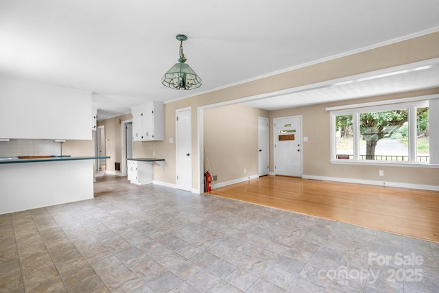 1753 28th St NE, Hickory, NC 28601 - unfurnished living room with stone finish flooring, baseboards, and crown molding