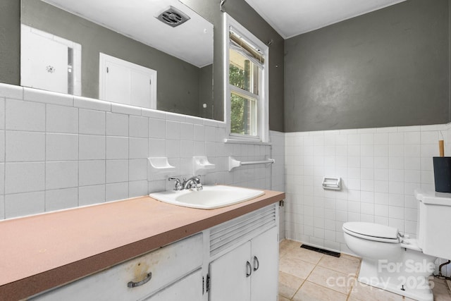 1753 28th St NE, Hickory, NC 28601 - bathroom featuring tile walls, tile patterned floors, toilet, vanity, and a wainscoted wall