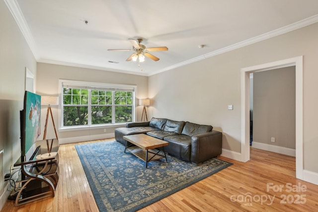 living area featuring ceiling fan, hardwood / wood-style floors, crown molding, and baseboards