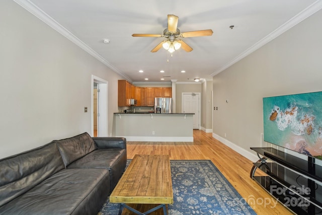 living area with a ceiling fan, ornamental molding, light wood-style flooring, recessed lighting, and baseboards