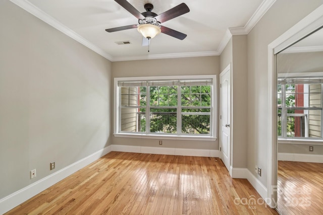 unfurnished room with plenty of natural light, light wood-style floors, baseboards, and crown molding