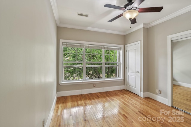 unfurnished bedroom with ornamental molding, hardwood / wood-style floors, baseboards, and ceiling fan