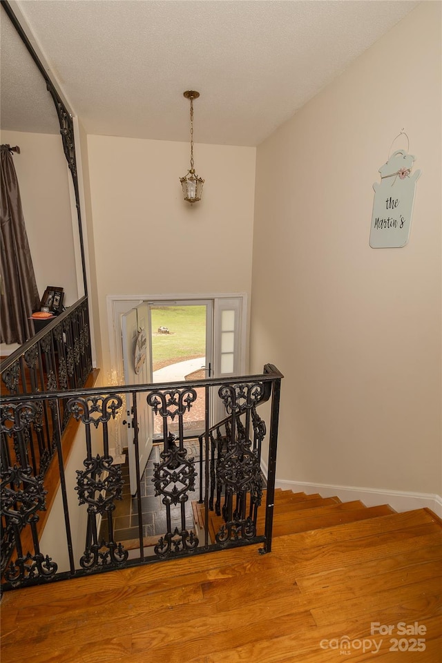staircase with wood finished floors and baseboards