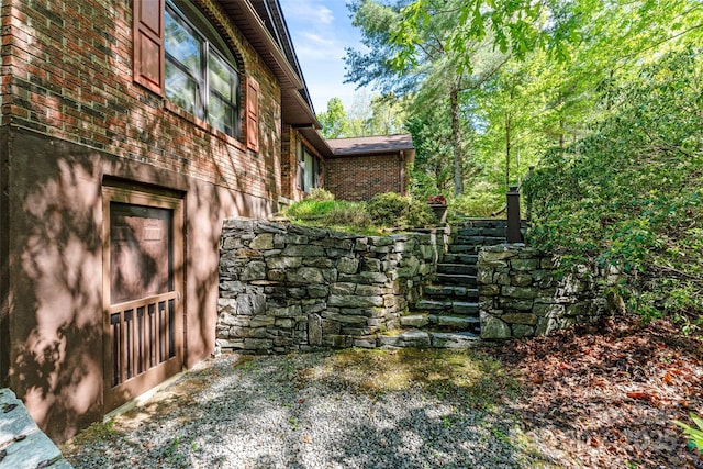 view of home's exterior featuring brick siding and stairway