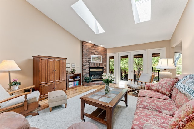 living area featuring a skylight, high vaulted ceiling, a fireplace, and wood finished floors