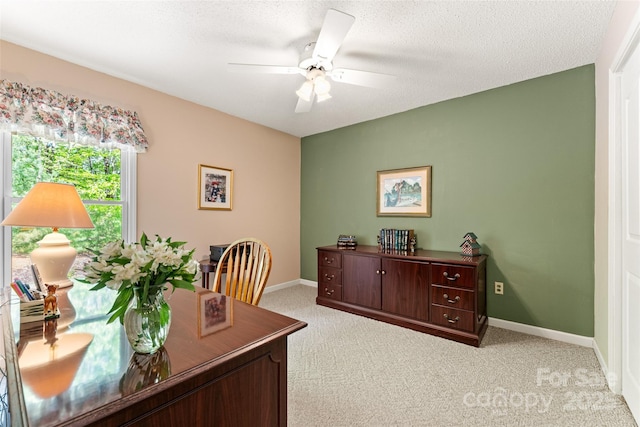 office featuring light carpet, ceiling fan, and baseboards