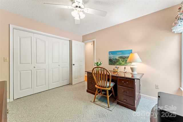 office area with a ceiling fan, a textured ceiling, baseboards, and carpet flooring
