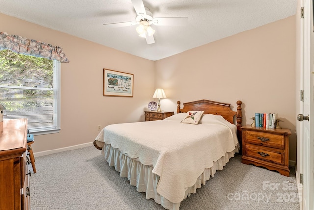bedroom with light colored carpet, baseboards, and a ceiling fan