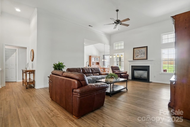 146 Burtons Barn Rd, Mooresville, NC 28115 - living room featuring a high ceiling, ceiling fan, wood finished floors, a fireplace with flush hearth, and baseboards