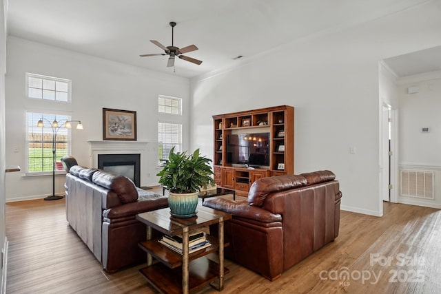 146 Burtons Barn Rd, Mooresville, NC 28115 - living area featuring ceiling fan, ornamental molding, a fireplace, light wood-style floors, and baseboards