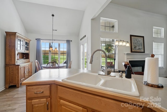 146 Burtons Barn Rd, Mooresville, NC 28115 - kitchen with a sink, a fireplace, vaulted ceiling, decorative light fixtures, and light wood finished floors