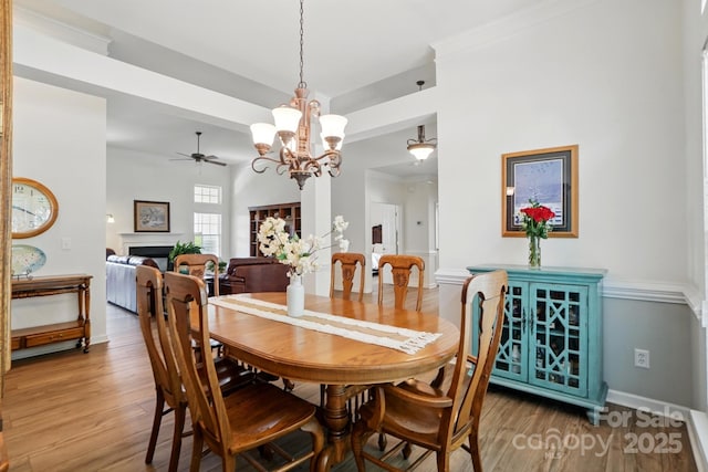146 Burtons Barn Rd, Mooresville, NC 28115 - dining room with a ceiling fan, wood finished floors, a chandelier, baseboards, and a fireplace