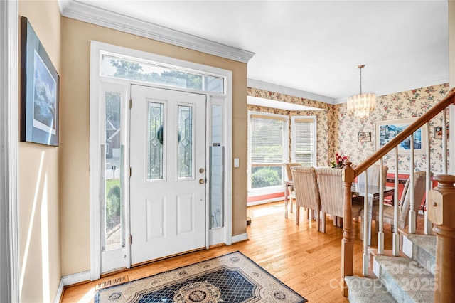 5238 Downing Creek Dr, Charlotte, NC 28269 - foyer featuring ornamental molding, a chandelier, baseboards, light wood-style flooring, and stairs