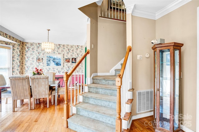 5238 Downing Creek Dr, Charlotte, NC 28269 - stairway featuring crown molding, wood-type flooring, a chandelier, wallpapered walls, and baseboards