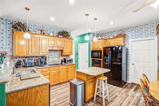 5238 Downing Creek Dr, Charlotte, NC 28269 - kitchen with black appliances, wallpapered walls, a sink, light wood finished floors, and light stone countertops