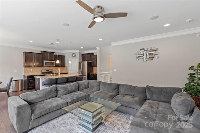 living room with ceiling fan, recessed lighting, wood finished floors, and ornamental molding