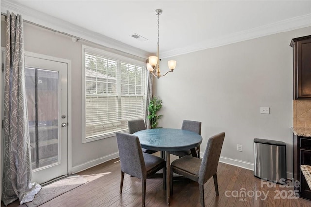 dining space featuring baseboards, crown molding, dark wood-style flooring, and a chandelier