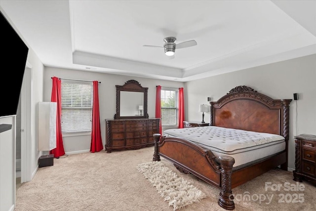 bedroom with a raised ceiling, carpet flooring, a ceiling fan, and baseboards
