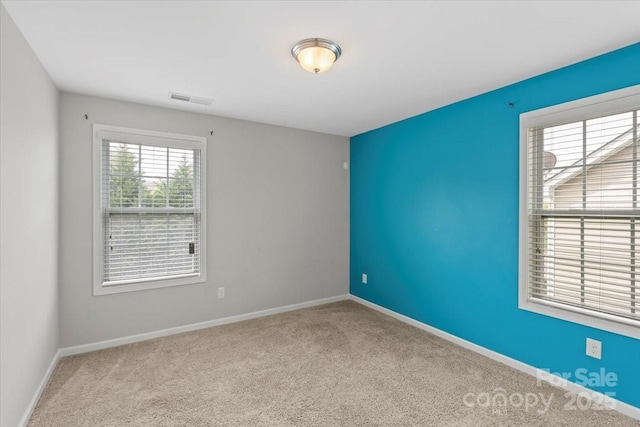 carpeted spare room featuring baseboards