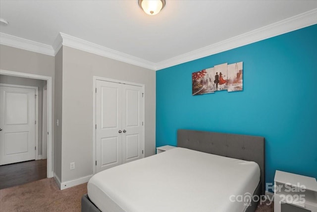 carpeted bedroom featuring ornamental molding, baseboards, and a closet