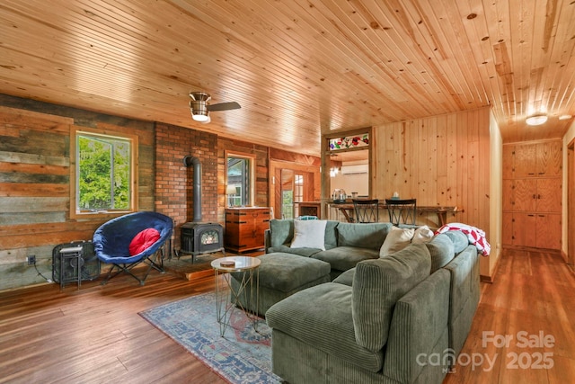 1925 Green Hill Rd, Blowing Rock, NC 28605 - living area with a wood stove, wood walls, wood ceiling, hardwood / wood-style floors, and a ceiling fan