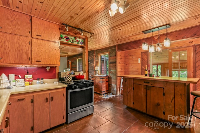 1925 Green Hill Rd, Blowing Rock, NC 28605 - kitchen with gas stove, light countertops, dark tile patterned floors, wood walls, and wooden ceiling
