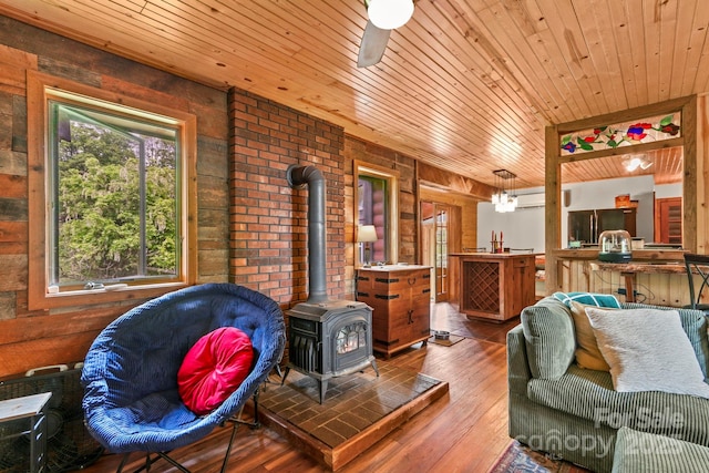 1925 Green Hill Rd, Blowing Rock, NC 28605 - living area with a wood stove, wood ceiling, wood walls, and wood-type flooring