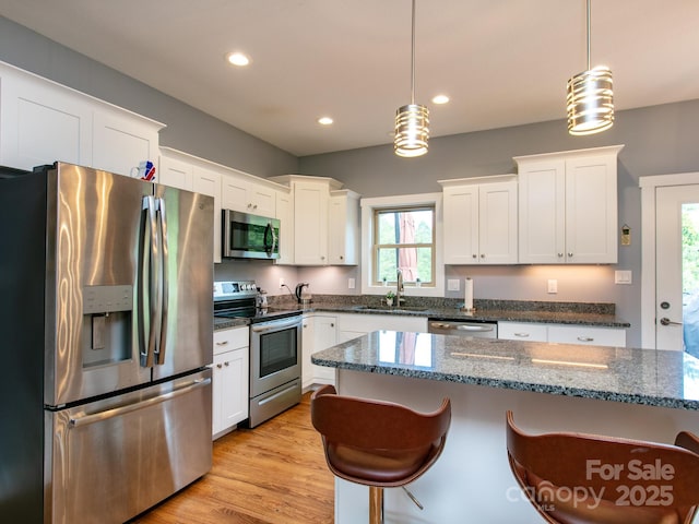 5 S Pine Dr, Weaverville, NC 28787 - kitchen with stainless steel appliances, a sink, a breakfast bar area, white cabinets, and recessed lighting