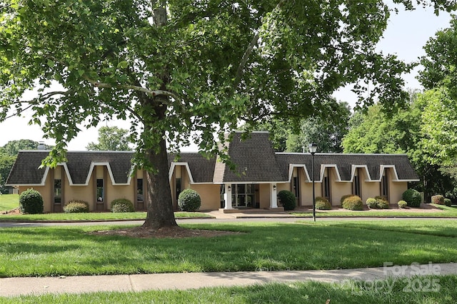8306 Knights Bridge Rd, Charlotte, NC 28210 - view of front of house featuring a shingled roof, a front lawn, stucco siding, and mansard roof