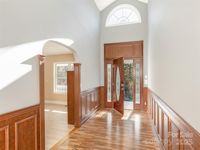 530 Stoney Mountain Rd, Hendersonville, NC 28791 - entryway with light wood finished floors, plenty of natural light, a wainscoted wall, high vaulted ceiling, and arched walkways