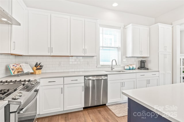 5210 Kelly St, Charlotte, NC 28205 - kitchen with stainless steel appliances, under cabinet range hood, a sink, light countertops, and white cabinets